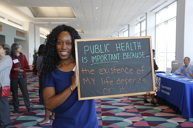 Woman holding a blackboard that says: Public health is important because: the existence of my life depends on it.